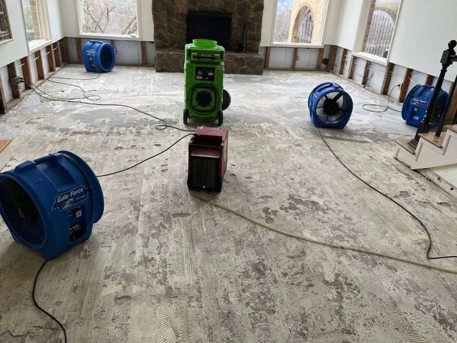 Commercial-grade air movers and dehumidifier deployed in a water-damaged room